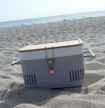 Der Everdure Cube am Strand Der Everdure Cube in grau steht am Strand, im Hintergrund das Meer.