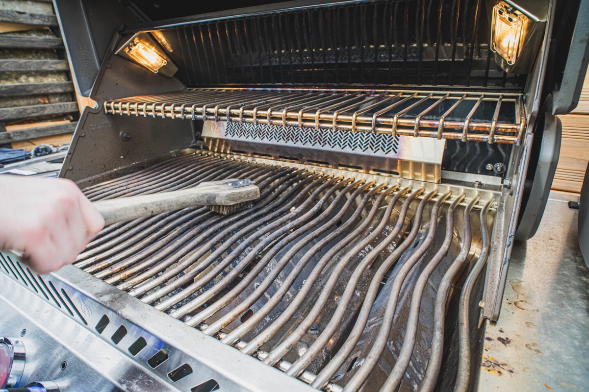 Grillreinigung mit Grillbürste Reinigen Sie vor allem den Grillrost, um eingebranntes Fett und Fleischreste zu entfernen