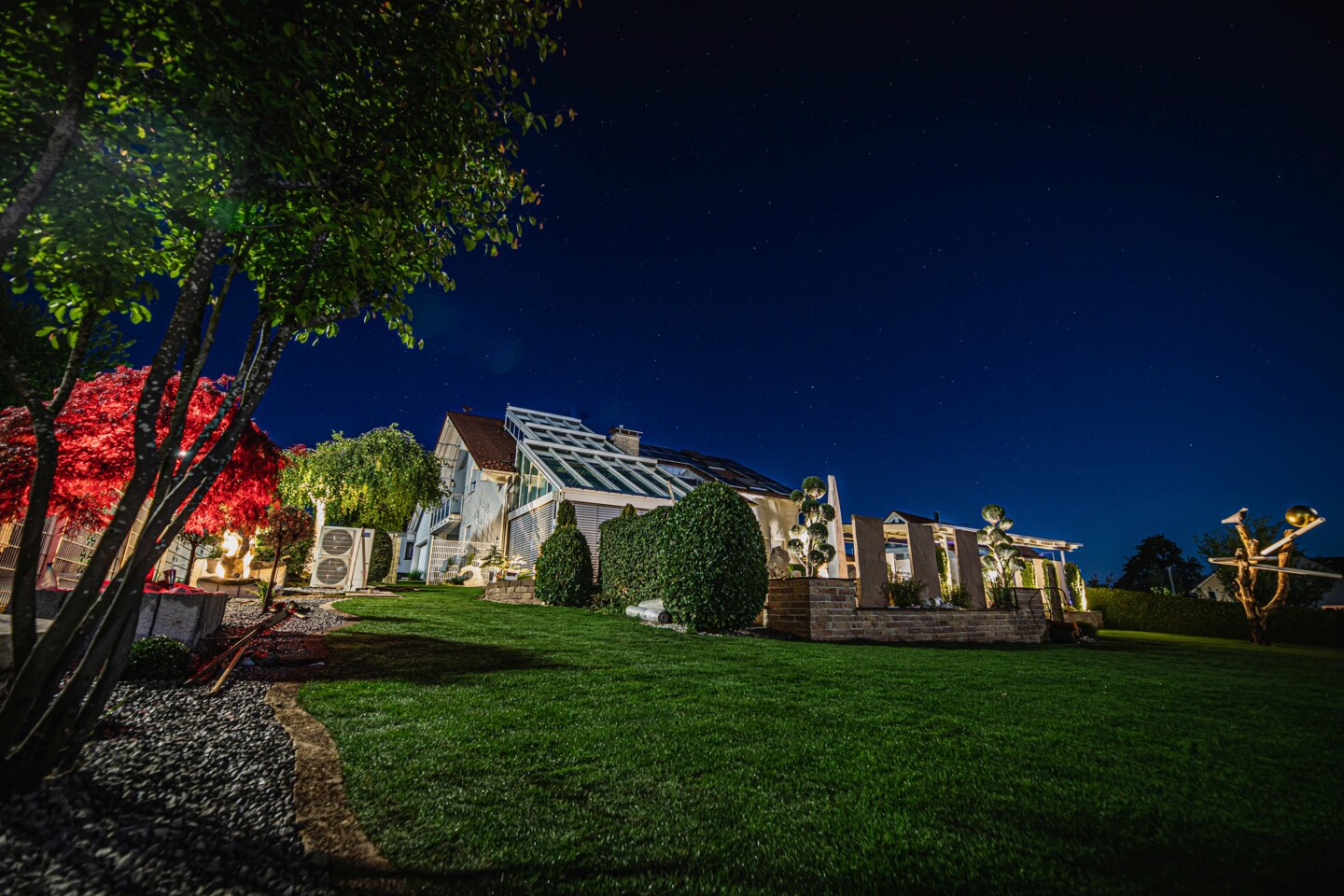 Blick auf das Grundstück mit Garten und atmosphärisch stimmiger Beleuchtung
