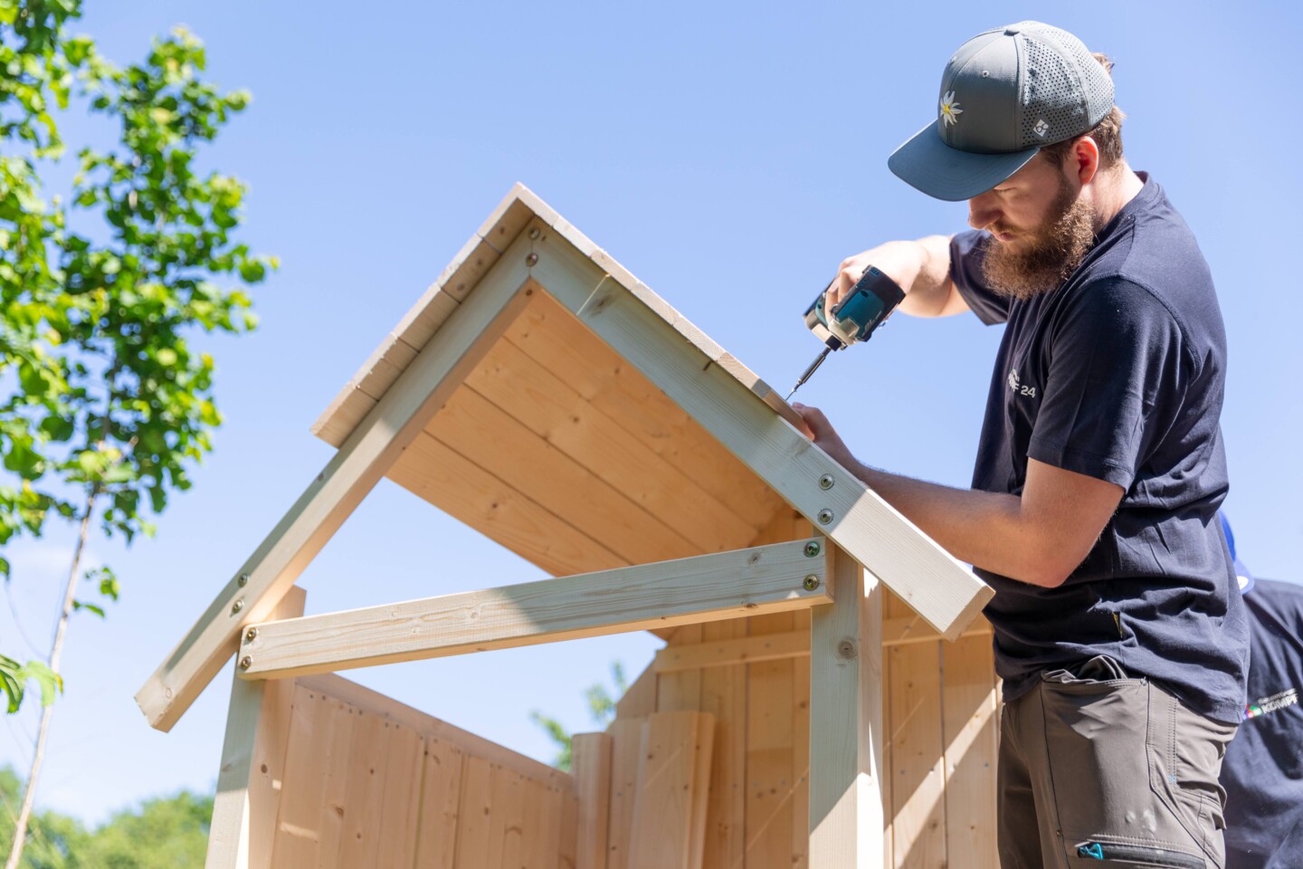 Ein kleines Dach wird von einem Mann mit Bart eingedecktngedeckt