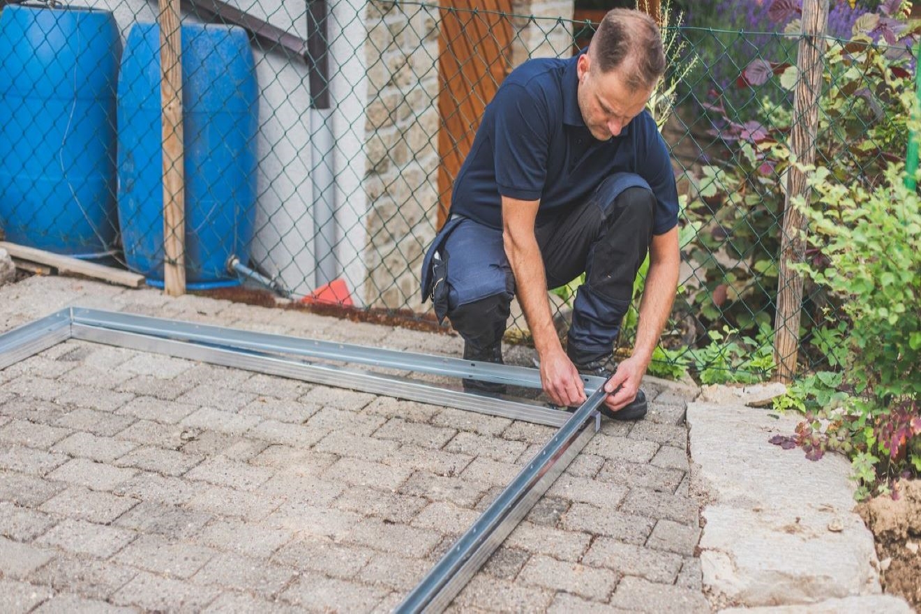 Monteur verschraubt das Biohort Bodenprofil auf dem Biohort Bodenrahmen