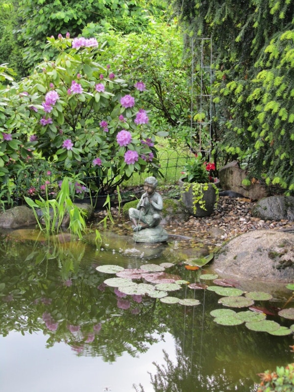 Flötenspieler Statue am Teich