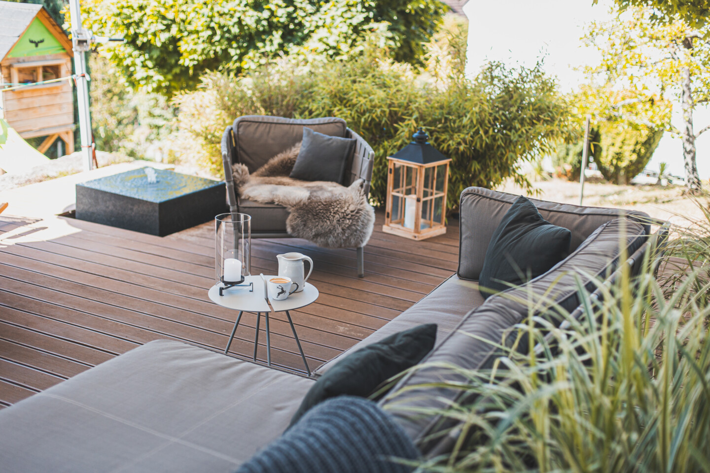 Eine gemütlich eingerichtete Holzterrasse mit Sofa und Sessel