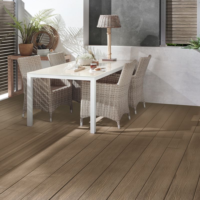 Terrasse aus graubraunen Dielen mit modernem weißen Tisch und Rattan Stühlen