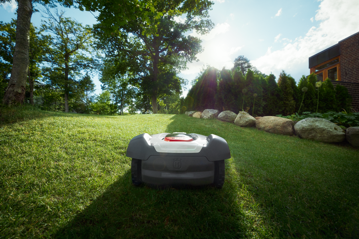 Mähroboter im Garten Ein Husqvarna Automower fährt einen Hügel hinauf