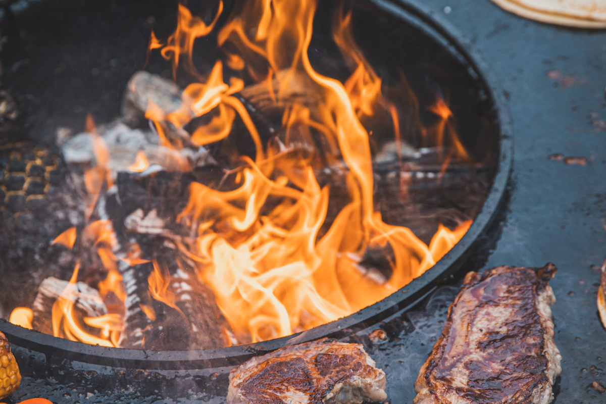Thema Grills Auf einer Feuerplatte werden zwei saftige Steaks gebraten