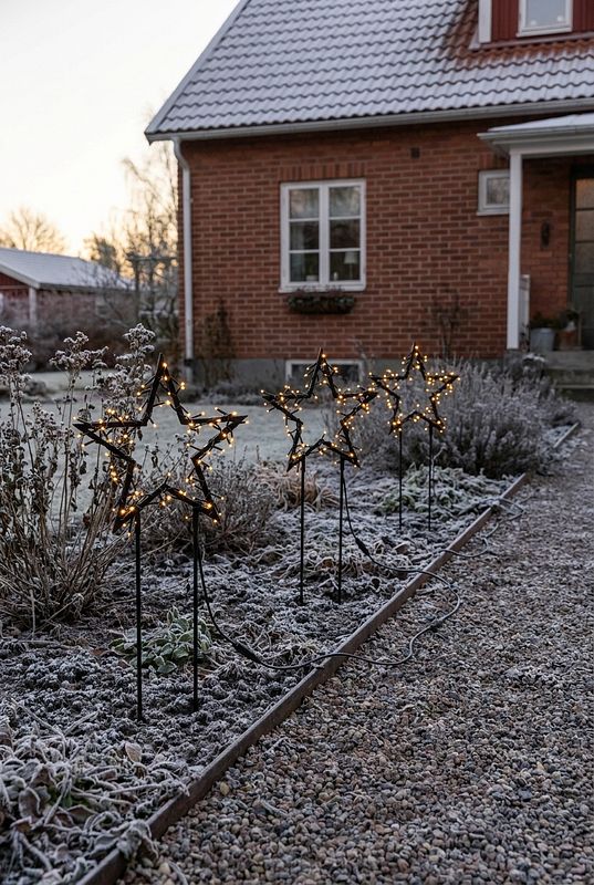 3 LED Leuchtsterne säumen den Weg zu einem Backsteinhaus