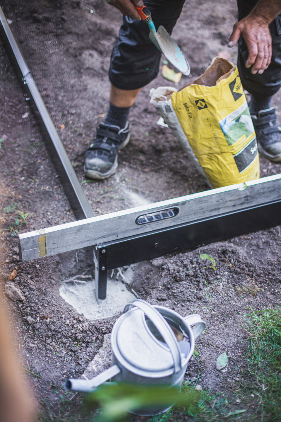 Die Löcher für das Fundament werden mit Schnellbeton ausgefüllt