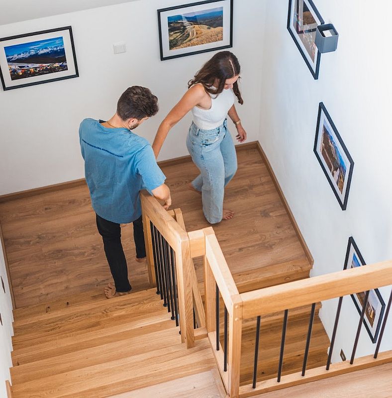 Renovierte Treppe, auf der ein Paar Hand in Hand die Stufen hinabsteigt.