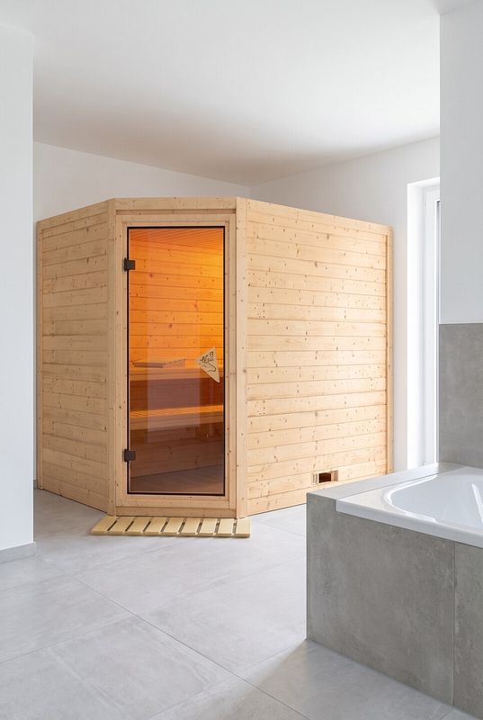 Innensauna aus hellem Holz auf großformatigen grauen Bodenfliesen