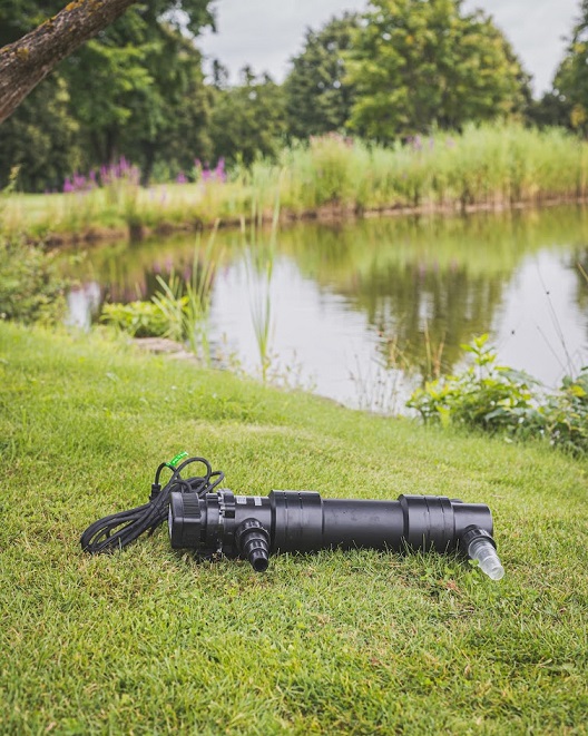 Teichpumpe liegt vor einem Teich