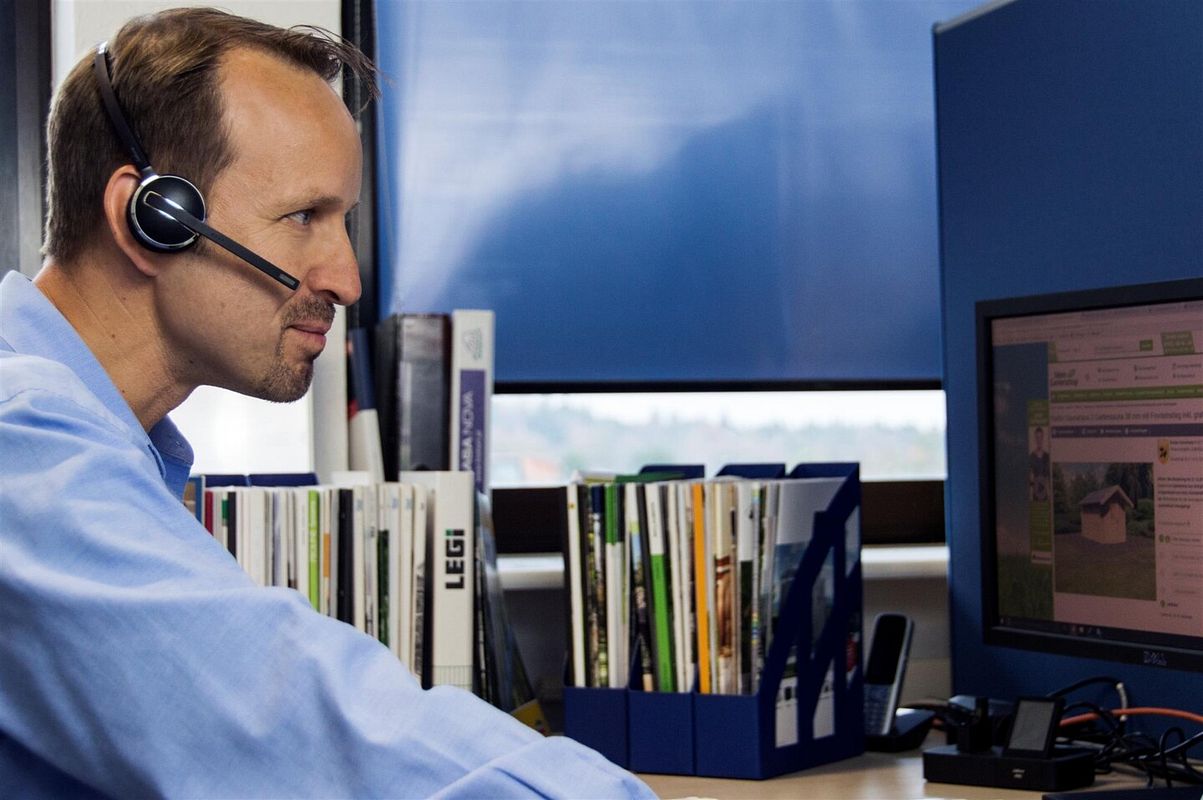 Fachberater mit Headset vor Computer