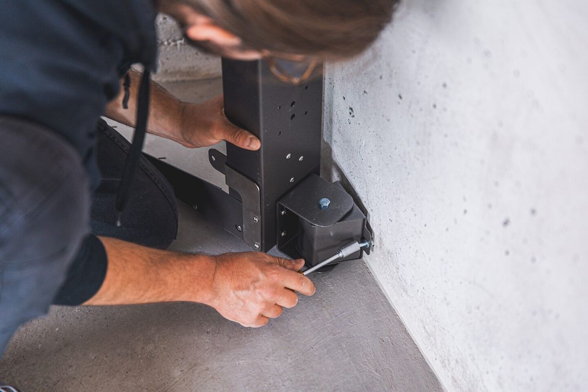 Die Distanzstücke der Schwenvorrichtung werden an die Wand geschraubt