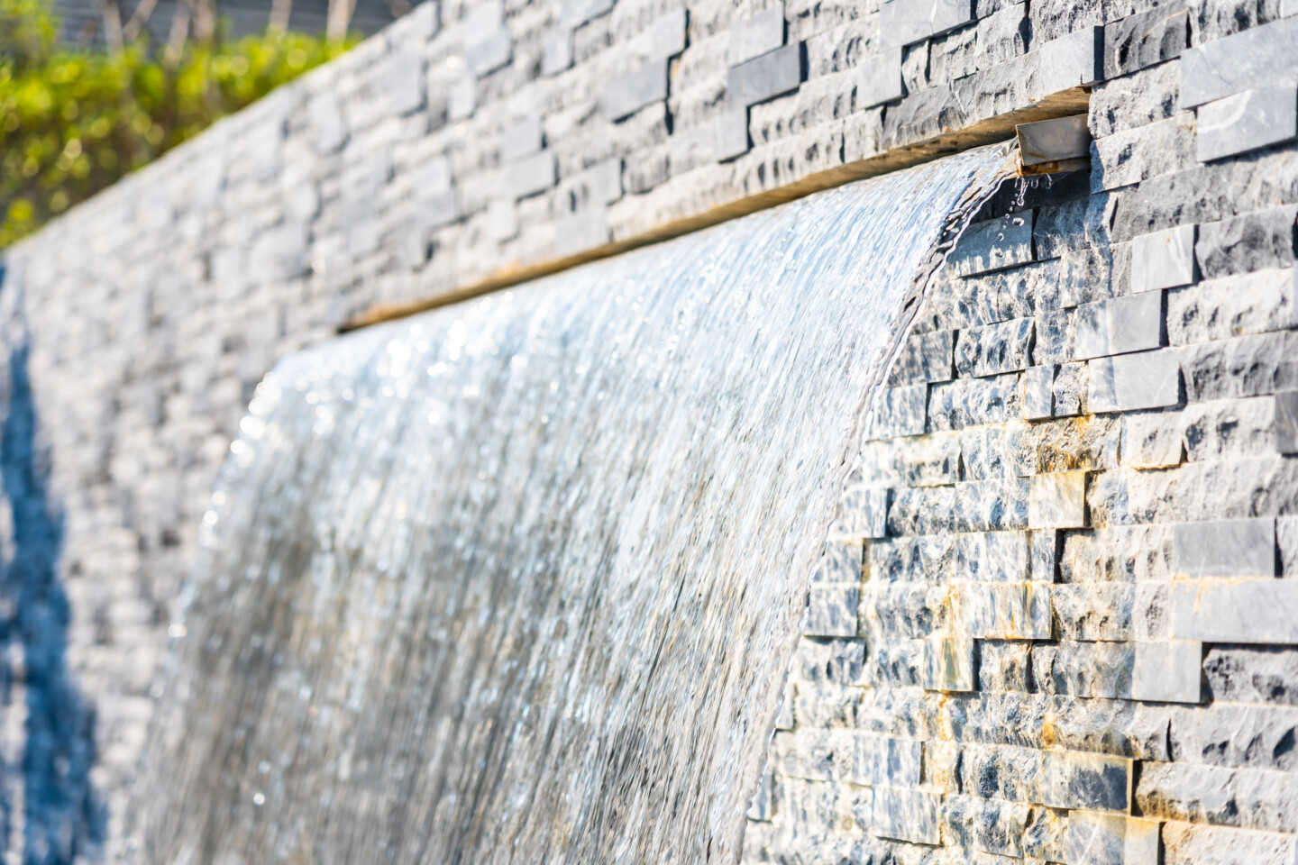 Künstlicher Wasserfall an Gartenmauer