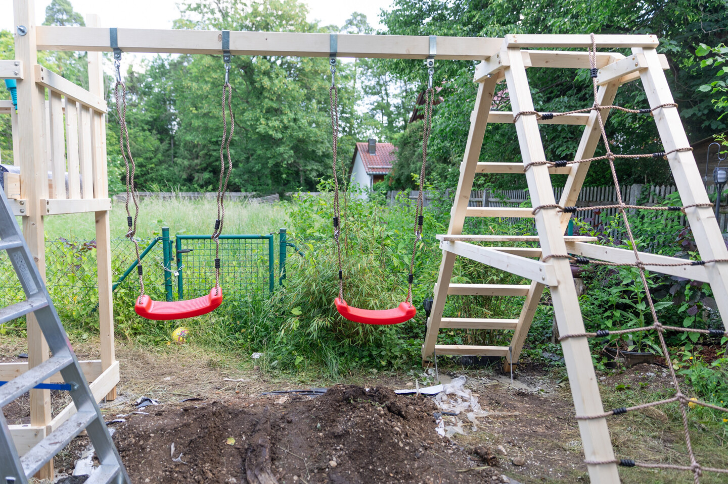 2 rote Schaukeln an einem Kinderspielgerät