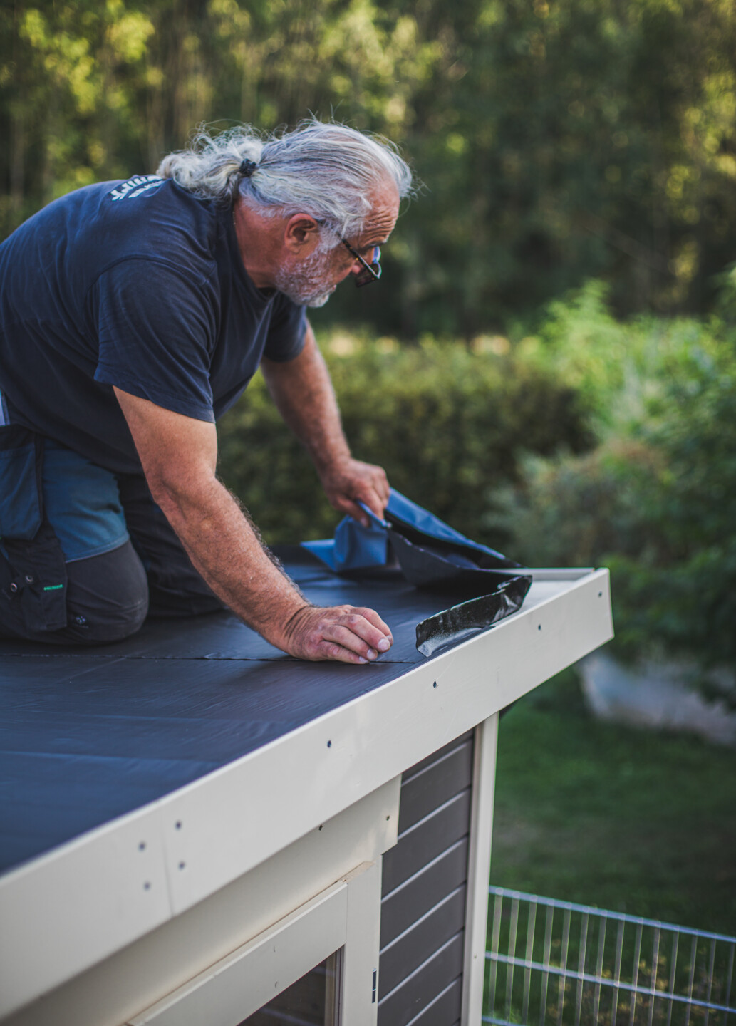 Die Klebefläche der Dachbahnen wird nach außen hin ausgestrichen, sodass sich keine Luftblasen bilden.