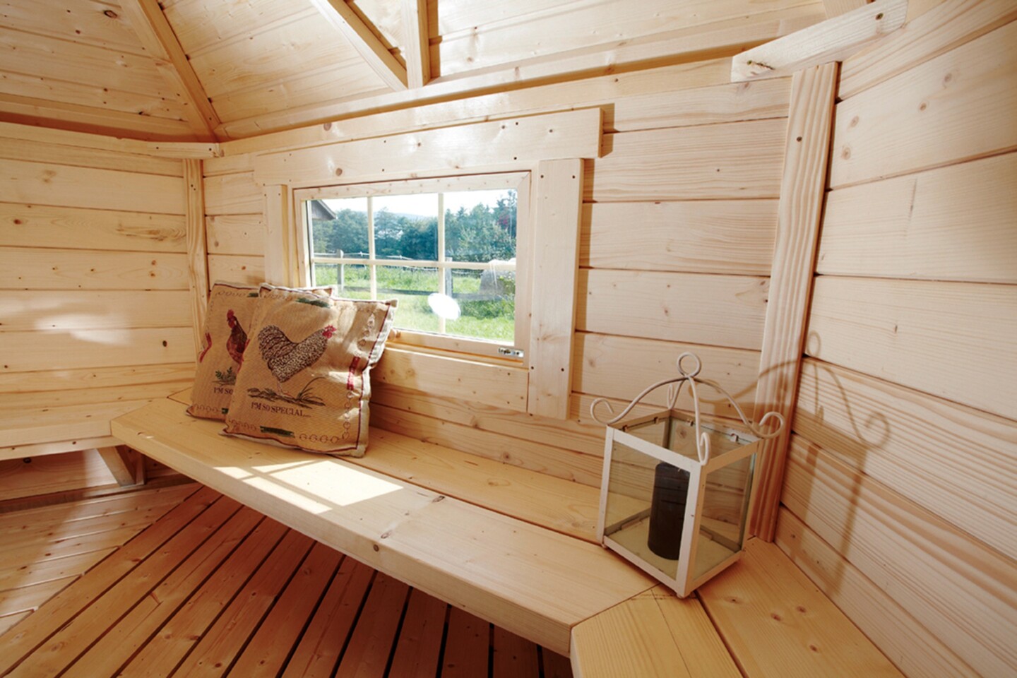 Sitzflächen in einer Grillkota mit Blick durch das Fenster