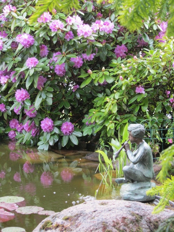 Flötenspieler Statue am Teich