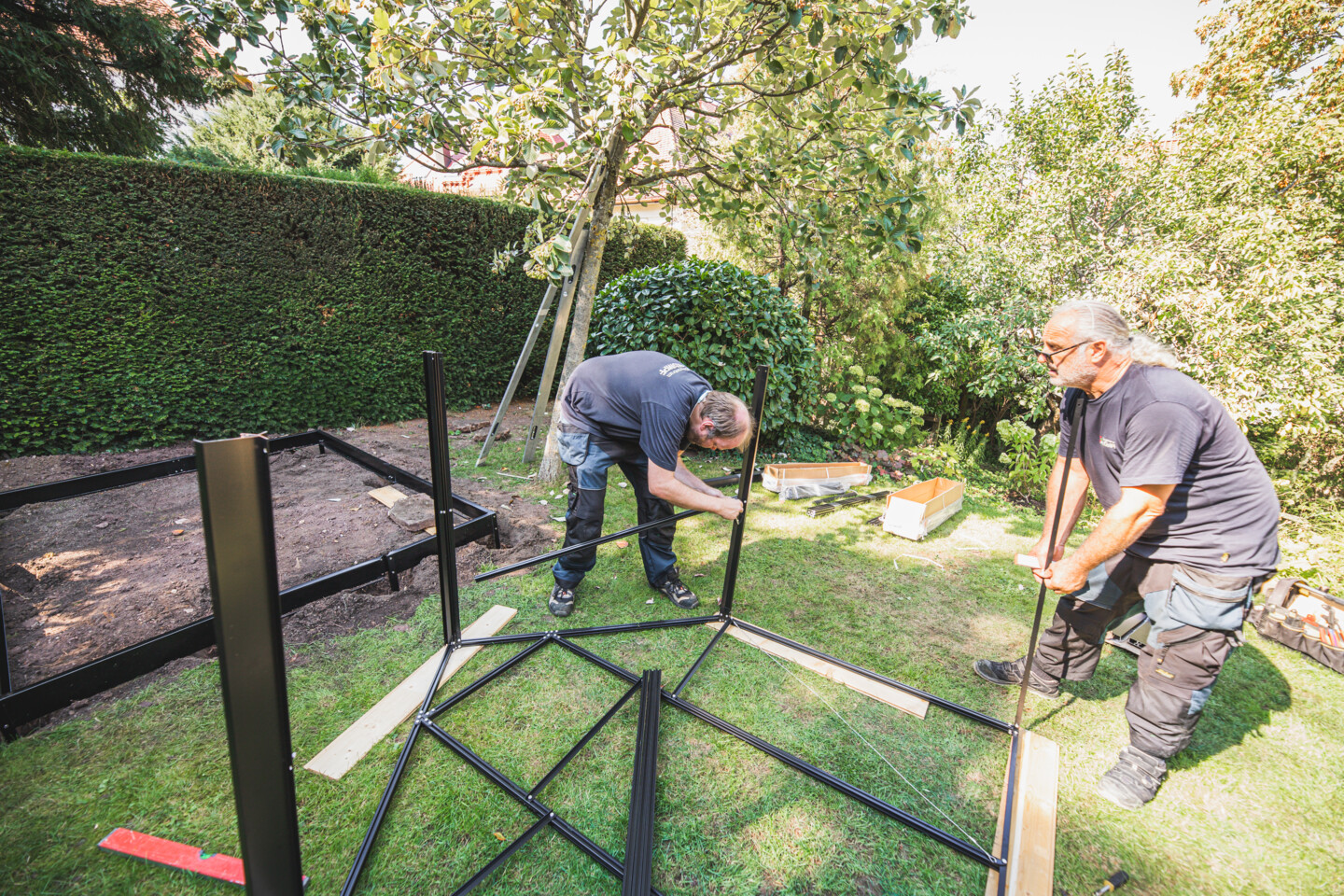 Die einzelnen Wandsegmente werden zu zwei halben Gewächshausrahmen zusammengesetzt.
