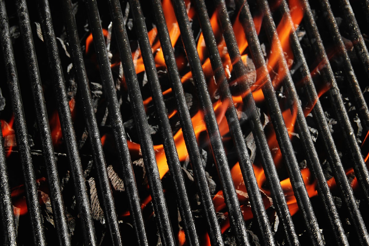 Schmutziger Rost über einem Holzkohlefeuer Pyrolyse hilft beim Reinigen des Grillrostes