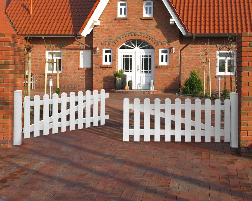 Weißes Gartentor vor Haus mit Klinkerfassade