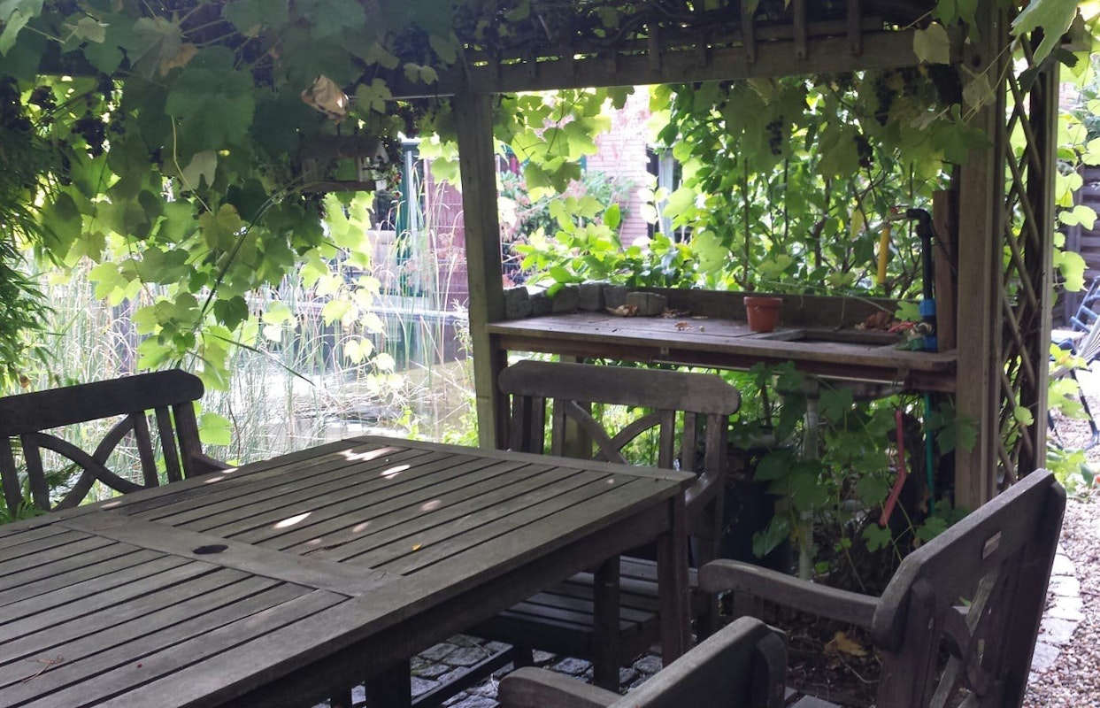 Pergula mit Tisch und Stühlen