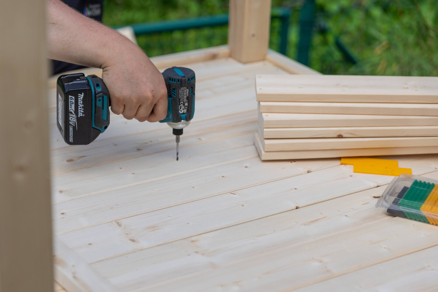 In der Mitte des Bodens wird eine Holzlatte von unten als zusätzliche Stütze dagegengeschraubt