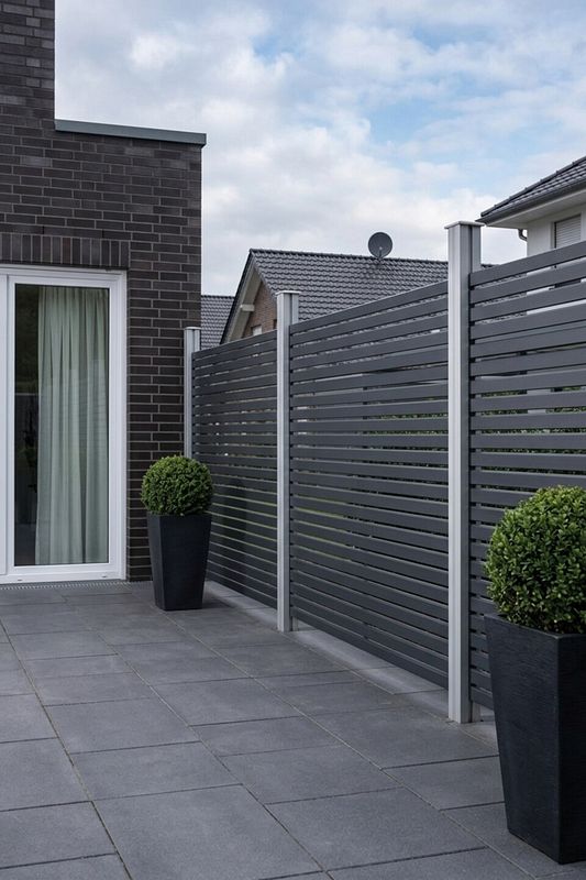 Moderner Lamellenzaun als Sichtschutz auf einer Terrasse