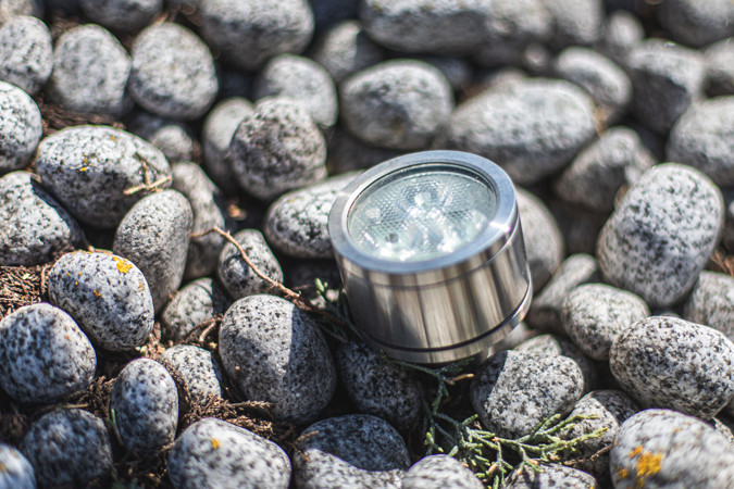 Ein kleiner LED-Strahler im Edelstahllook, der zwischen den Kieselsteinen kaum auffällt