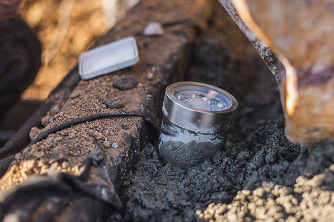 Ein kleiner Einbaustrahler, der am Sockel eines Steines eingegraben wird