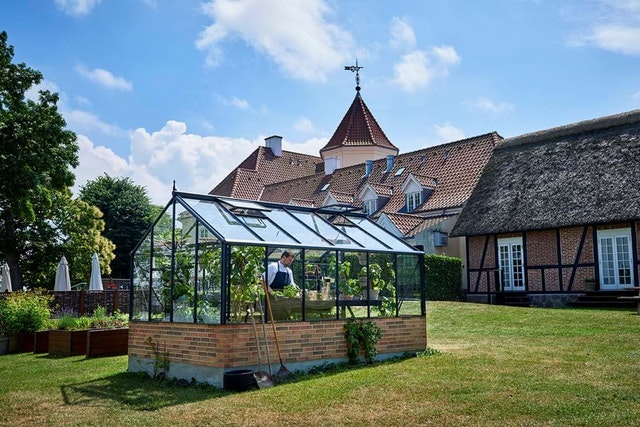 Besonders schick: ein Gewächshaus mit Mauer