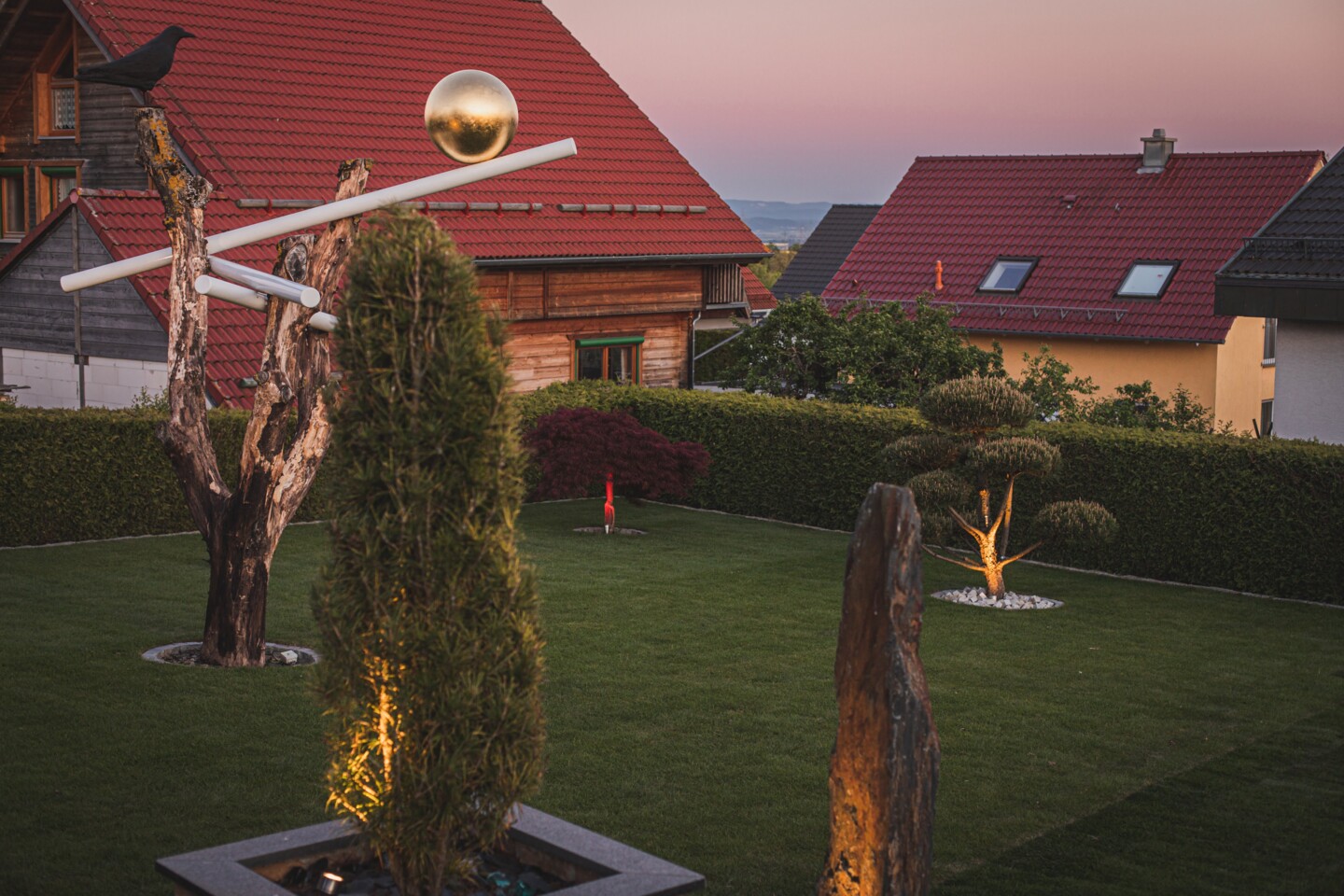 Einzelne Spots setzen Lichtakzente im Garten bei Dämmerung