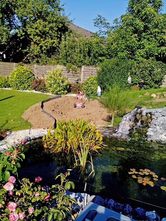 Anlegen eines Blumenbeetes neben dem Teich Der Teichaushub wurde flach verteilt und mit einer Begrenzung eingefasst.