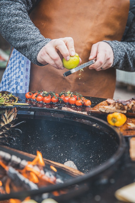 Gebratene Tomaten mit Limettenschale Jede Menge Obst und Gemüse wird auf der Grillplatte gebraten