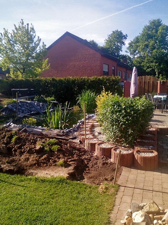 Koiteich direkt neben der Terrasse Der Koiteich passt sich perfekt an die Terrasse an, das Blumenbeet neben dem Teich ist noch unbepflanzt.