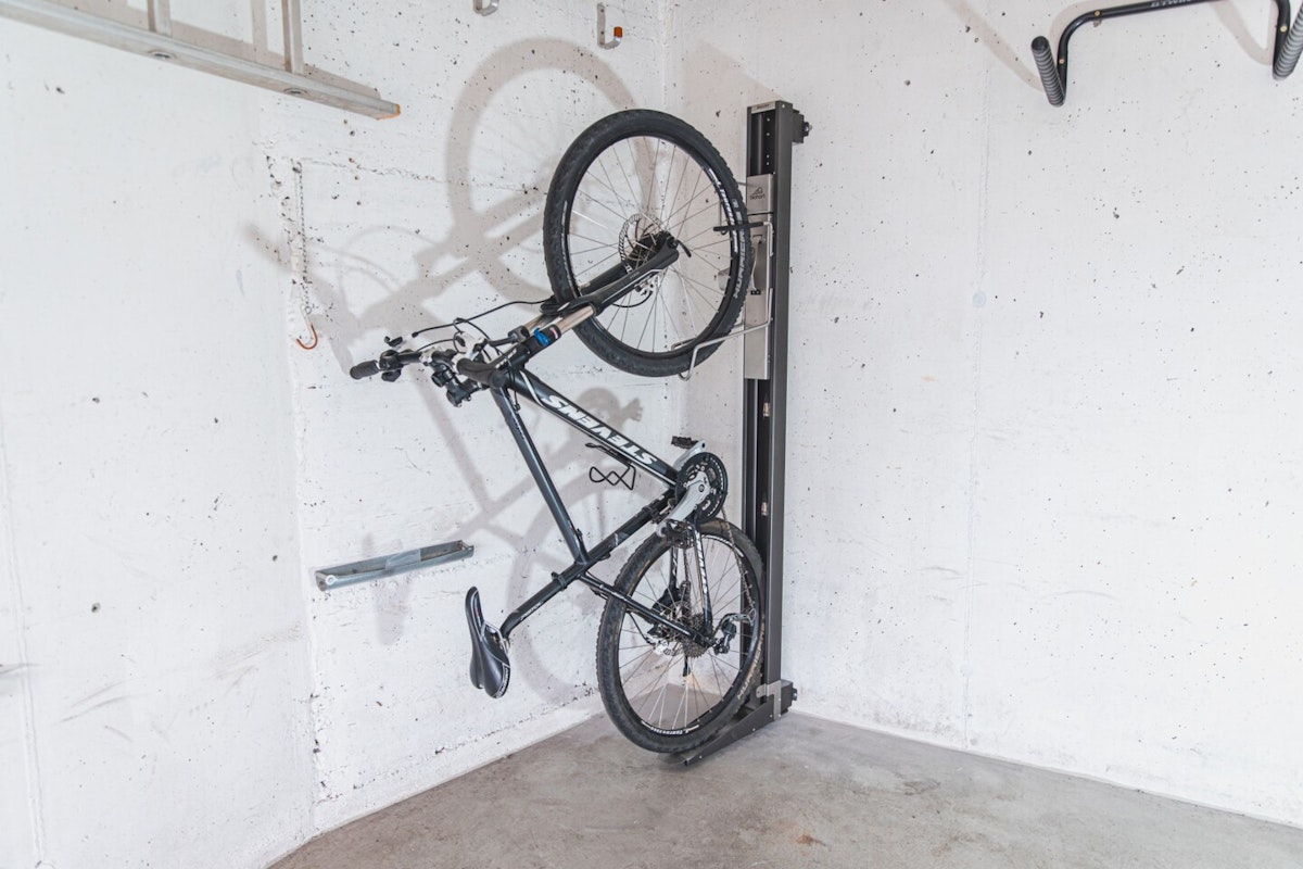 Fahrrad hängt an der Wand Das Fahrrad ist in der Wandhalterung mit Schwenkvorrichtung fixiert