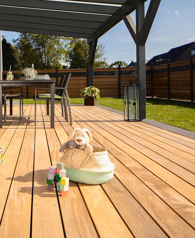 Terrasse mit hellen Holzdielen unter einer Überdachung aus dunklem Holz