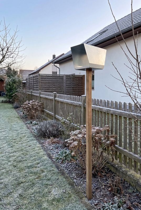 Ein Stahl-Futterhaus schützt Vogelfutter im frostigen Garten