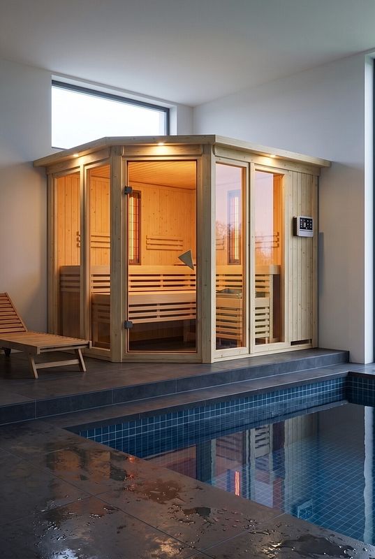 Großzügiger Wellnessraum mit verglaster Innensauna und Schwimmbecken