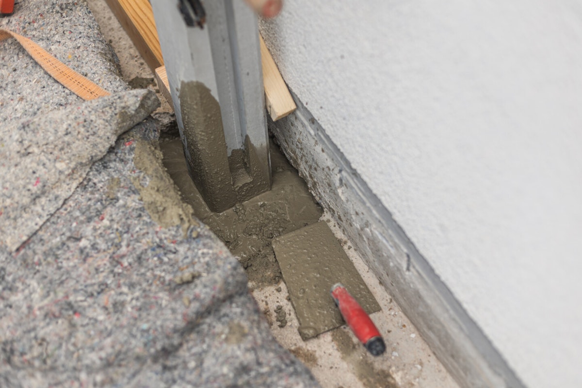 Beton eingießen Die Betonmasse wird um die Pfosten herum ausgegossen
