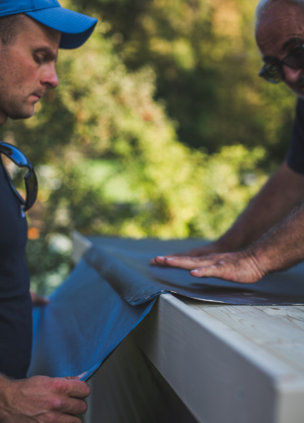 Die Dachbahnen werden vorsichtig, Stück für Stück aufgeklebt.