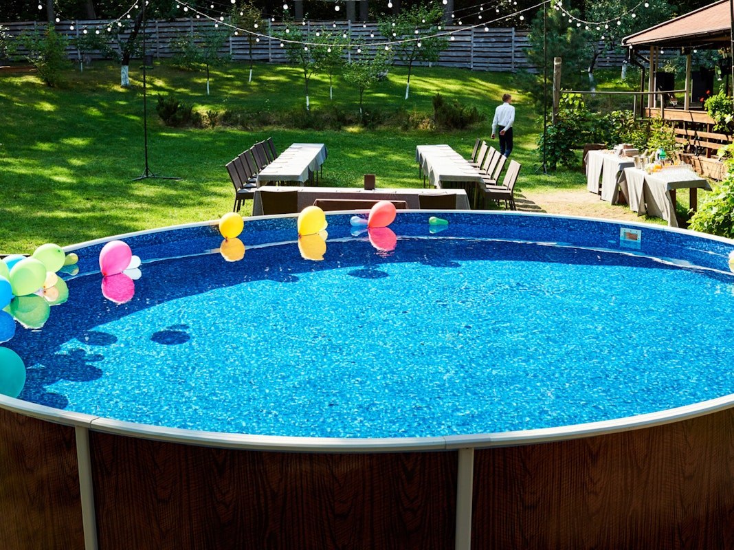 Highlight für die nächste Gartenparty Großer Stahlrahmenpool mit Luftballons an der Wasseroberfläche