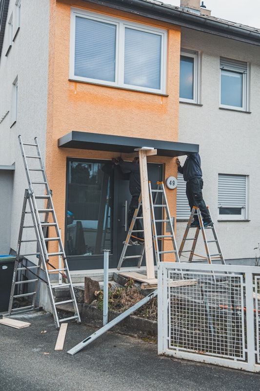 Vordach anbringen Um das Vordach über der Haustür anzubringen, muss man es in Position bringen und abstützen