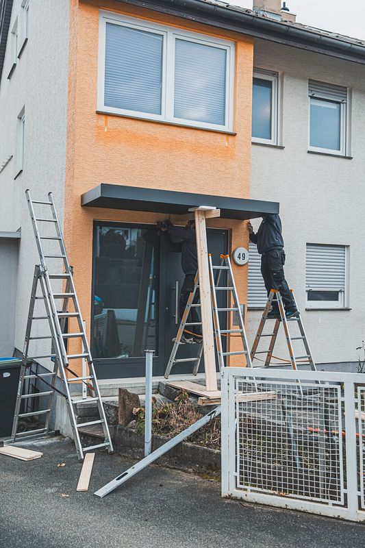 Um das Vordach über der Haustür anzubringen, muss man es in Position bringen und abstützen