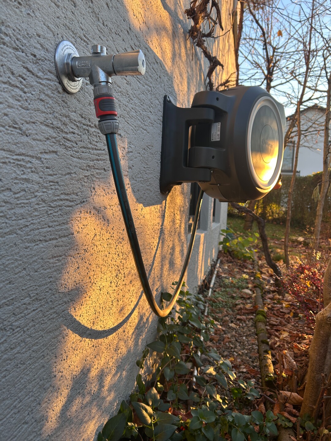 Außenwasserhahn an Hauswand mit Gartenschlauchtrommel