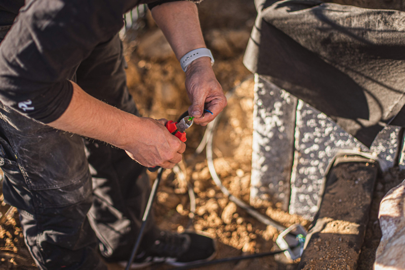 Unser Experte schließt kürzt das Kabel der Gartenbeleuchtung auf die richtige Länge