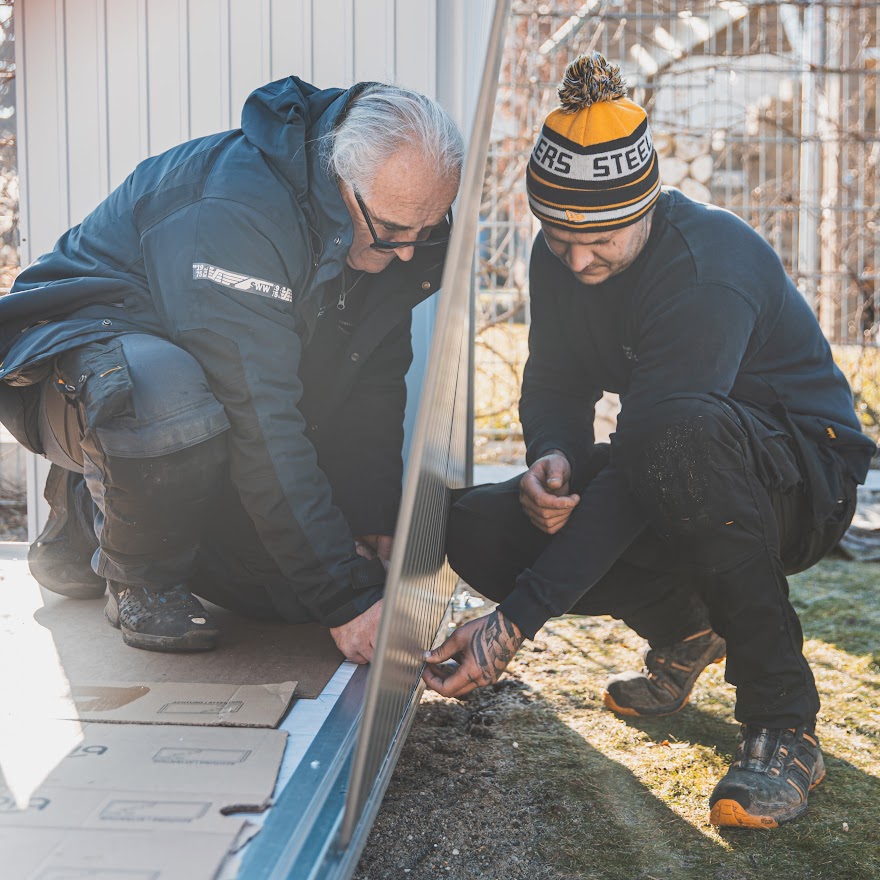 Biohort Panorama - Monteure stellen die Wände zu zweit: Von außen Schrauben durchführen, von innen verschrauben