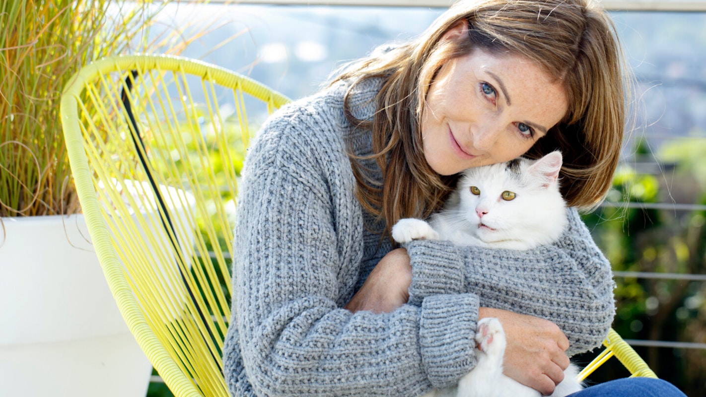 CAT'S LOVE Katzenliebe Frau hält weiße Katze im Arm