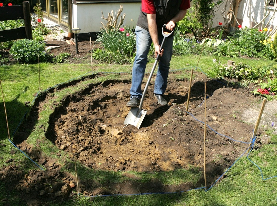 Teichbau Schritt 1: Den Teich ausheben Mit dem Spaten wird die Teichgrube in den Rasen gegraben.