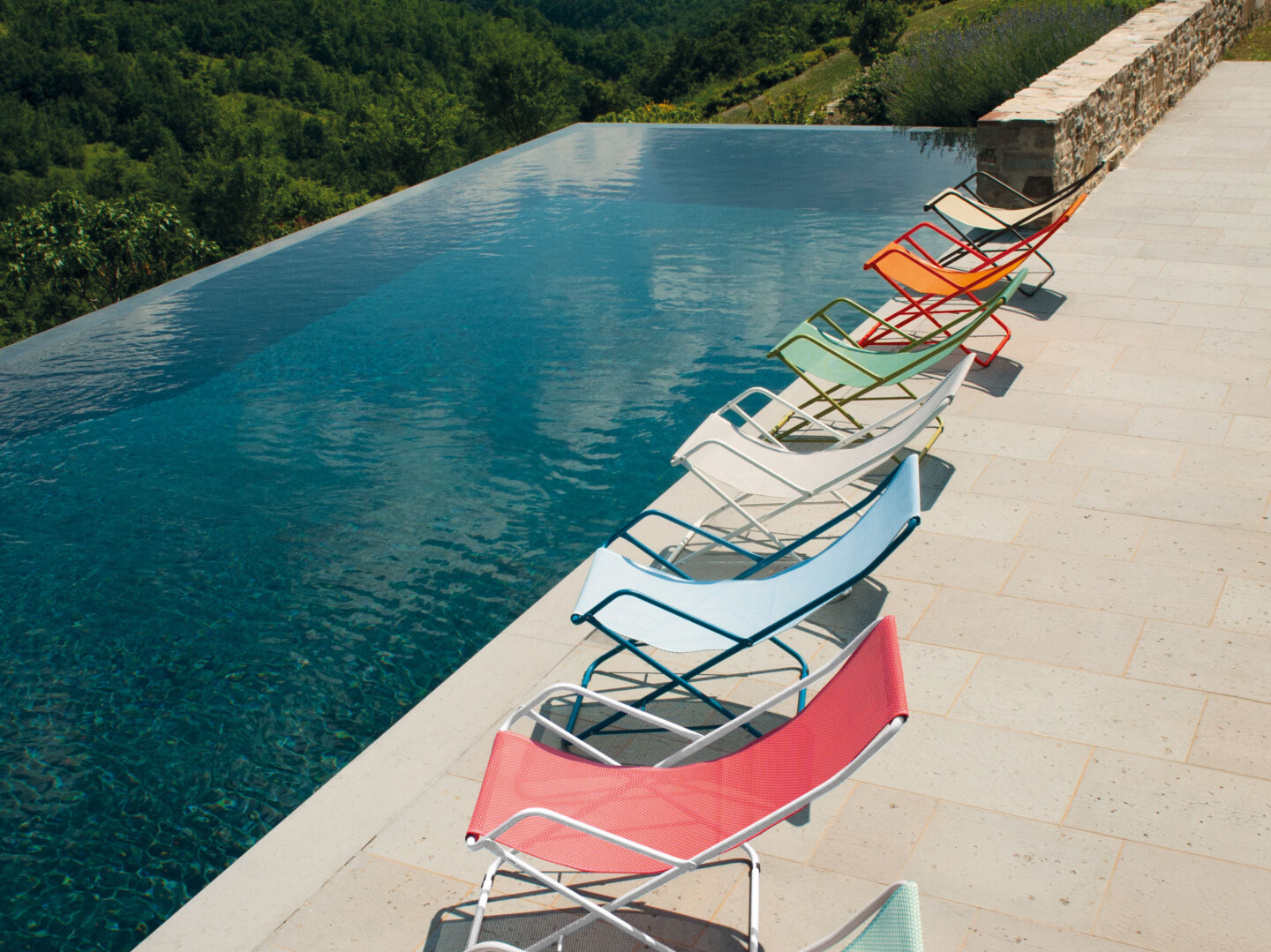 Farbenfrohe Liegestühle am Pool